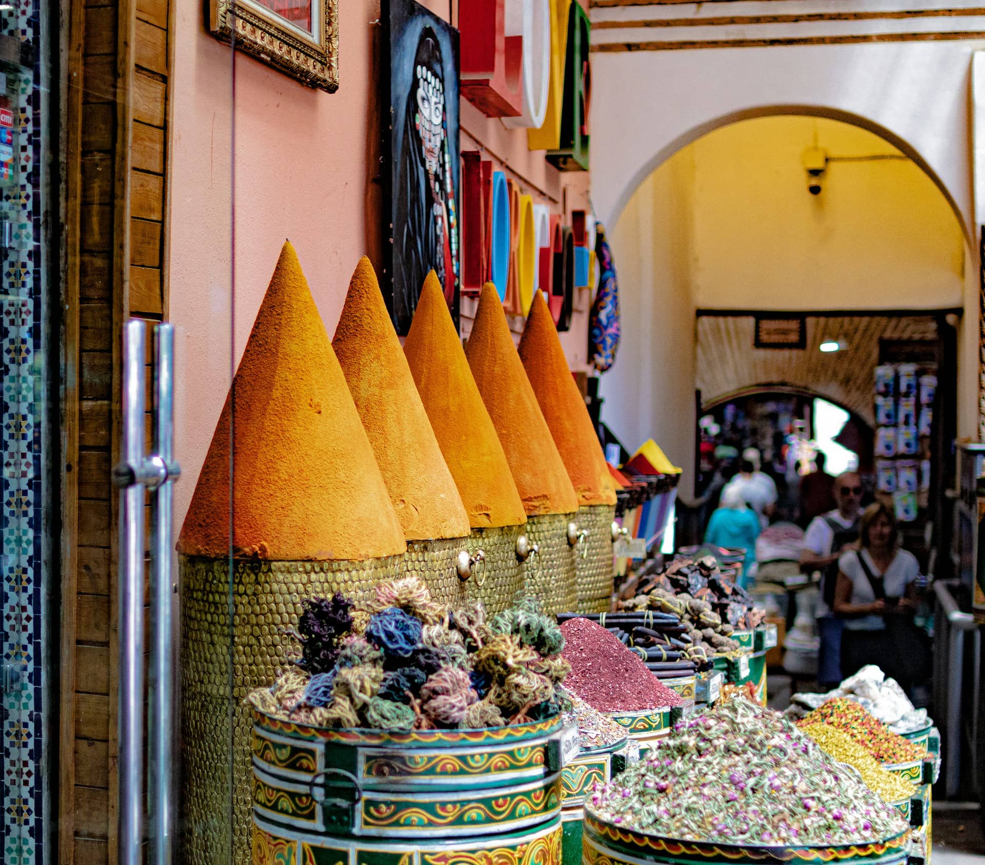 A vibrant display of spices and natural dyes in a bustling market in Marrakesh.