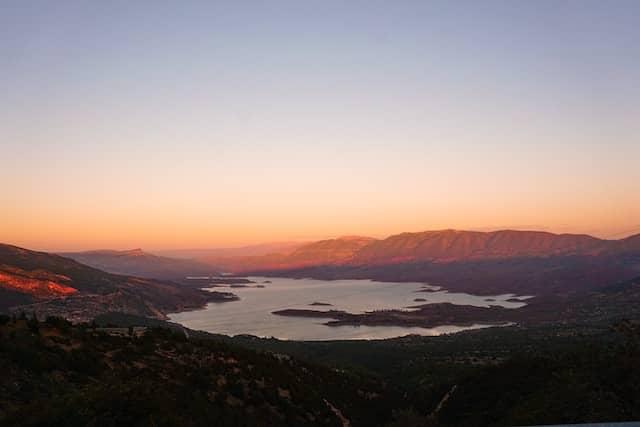 Scenic view of Bin El Ouidane Lake surrounded by mountains at sunset in Morocco.